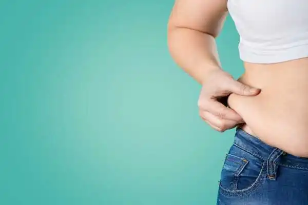 Image of woman pinching her love handles to show weight gain Falkirk